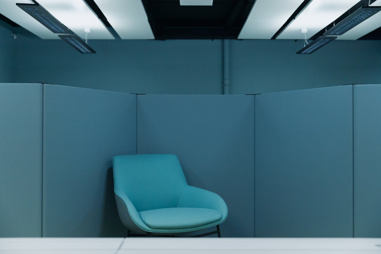 A serene office space featuring a stylish blue chair in a minimalist environment.